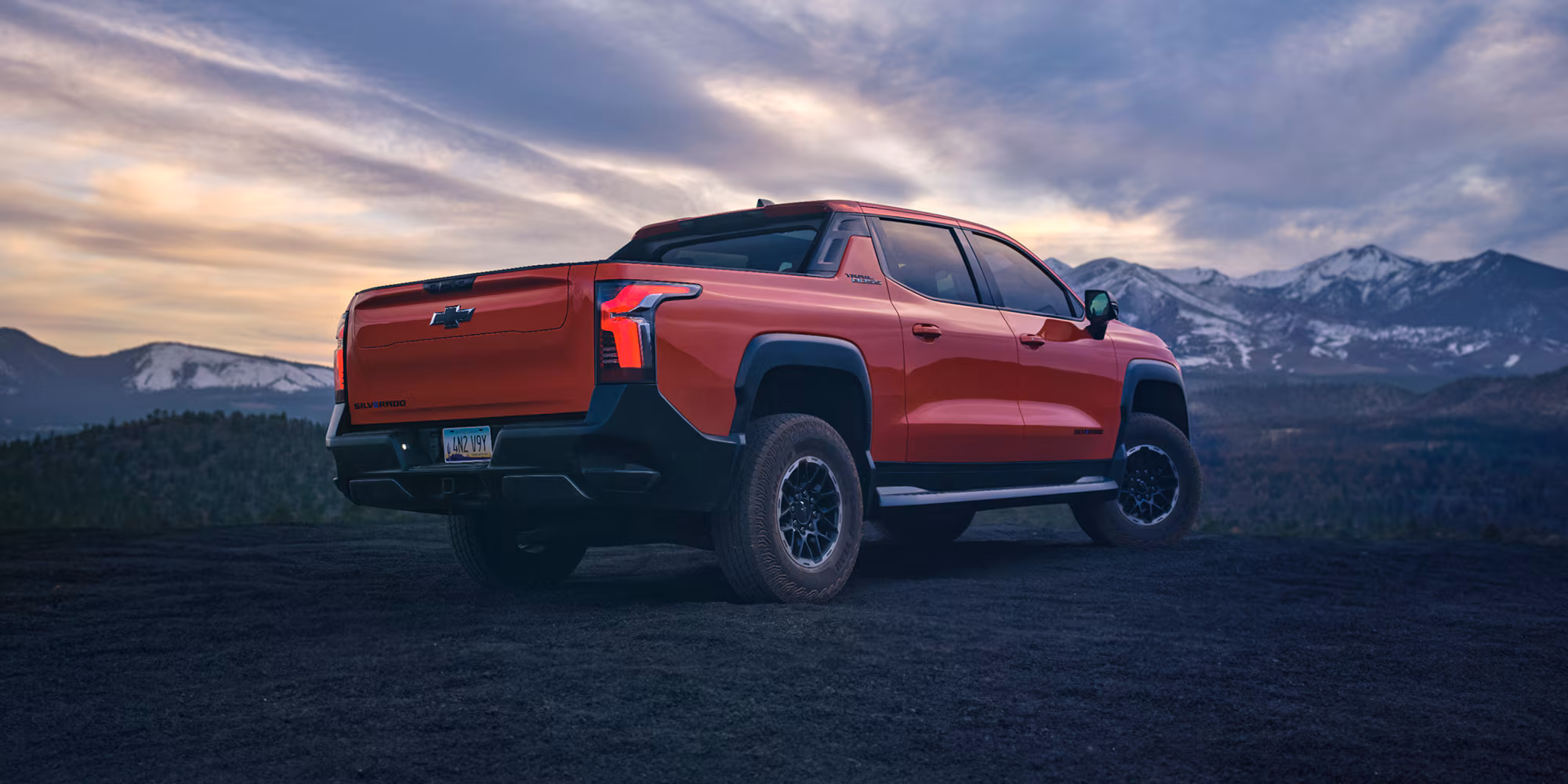 Exterior 2026 Chevy Silverado Ev Parked At Dusk With Mountainous Terrain In The B