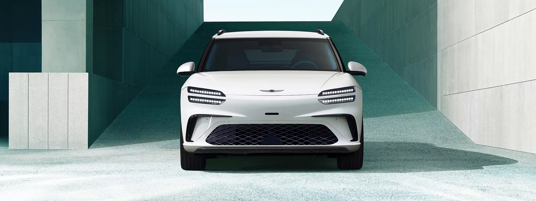 Exterior Front View Of 2026 Genesis Gv60 In White Framed By Modern Concre