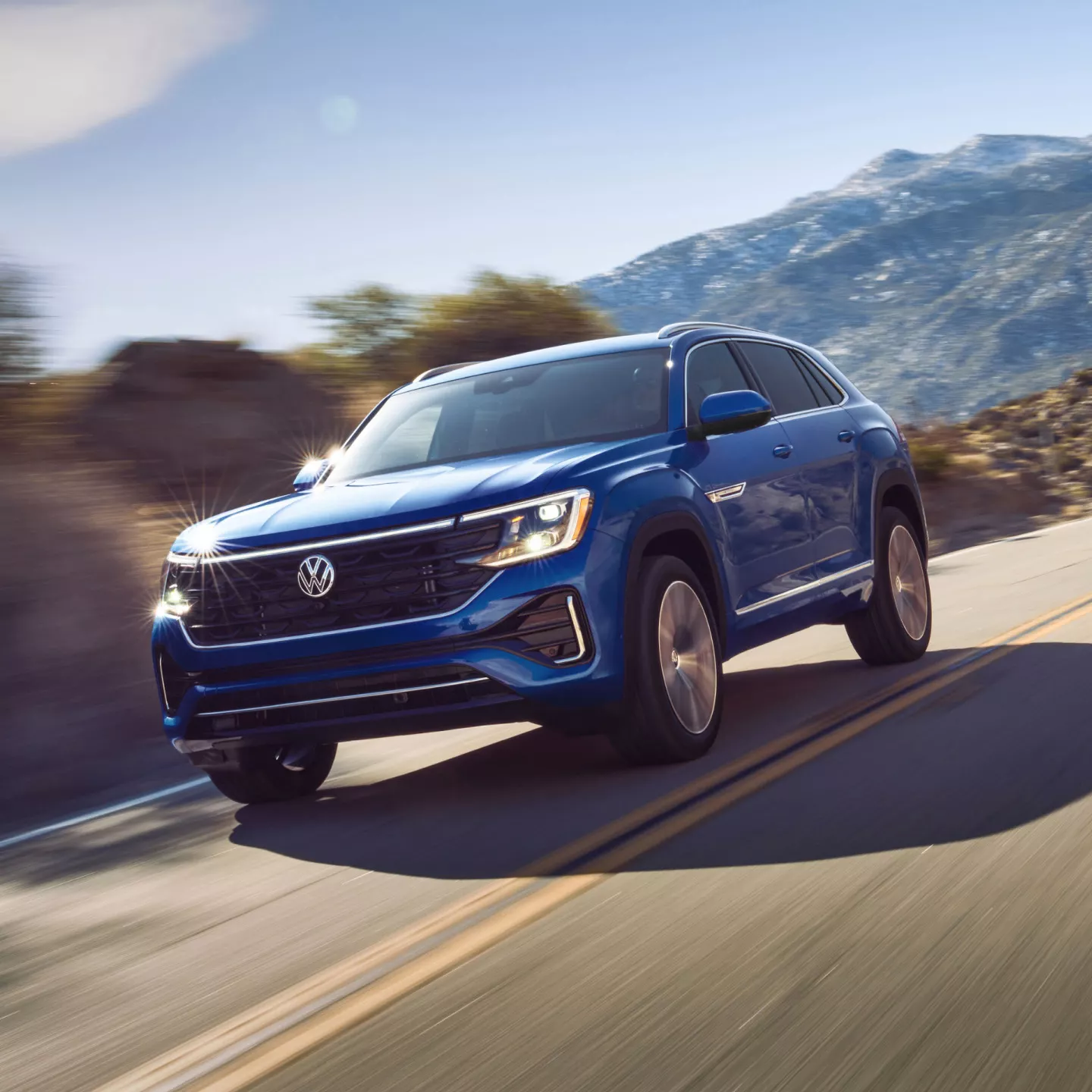 Exterior A Front View Of An Atlas Cross Sport Shown In Mountain Lake Blue Driving